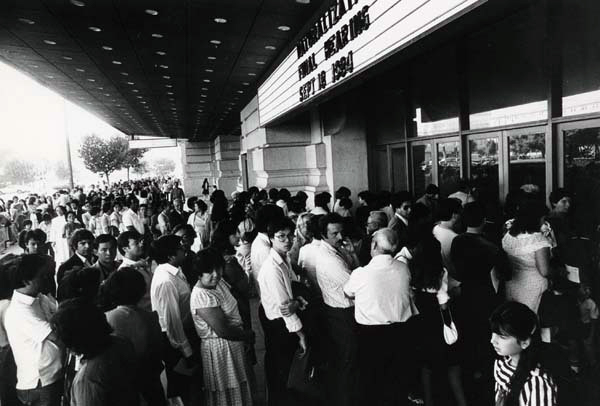Large crowd of people outside of theater.