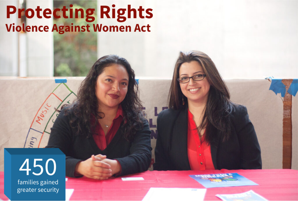 Two women sitting at what looks like a information booth or table.