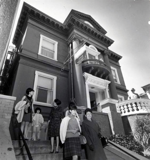 Shot of people in front of victorian house on Van Ness street.