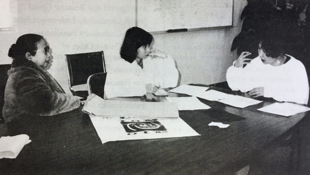 Three women seated at table.
